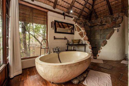雾观Tanamera Lodge的带窗户的房间里有一个大浴缸