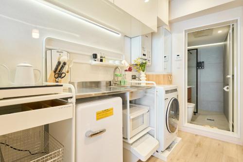 a white laundry room with a washer and dryer at STAY ARI Kabukicho in Tokyo