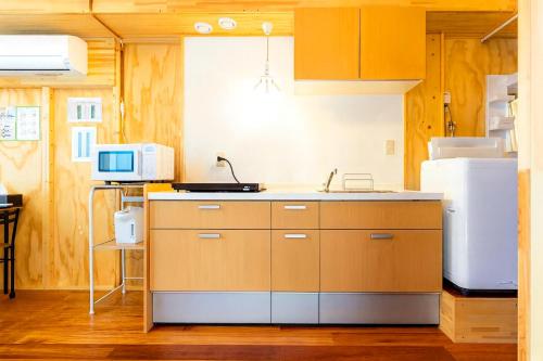 a kitchen with a sink and a refrigerator at MOBILITA COURT IWATE in Hachimantai