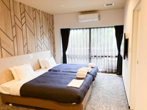 那霸ホテルリブマックス那覇波の上2的卧室里有一张大床，床上铺着毛巾。