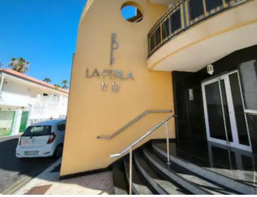 Un coche aparcado fuera de un edificio con una escalera. en La Perla Ocean View, en Puerto de Santiago