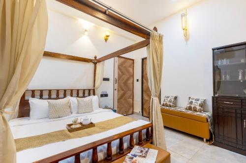 a bedroom with a bed and a tv at SaffronStays Shreevats in Bedla