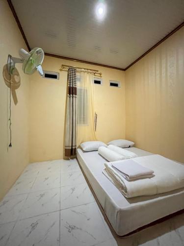 Ένα ή περισσότερα κρεβάτια σε δωμάτιο στο Komodo Homestay
