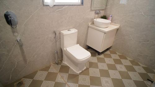 ein Badezimmer mit Toilette und Waschbecken in der Unterkunft Central suites with Terrace by Luxury Heights in Gurgaon
