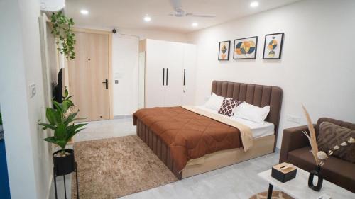 ein Schlafzimmer mit einem Bett und einer Couch in der Unterkunft Central suites with Terrace by Luxury Heights in Gurgaon