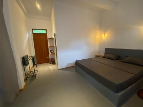 Un dormitorio con una cama y un televisor. en Bird garden Midigama, en Kumbalgama