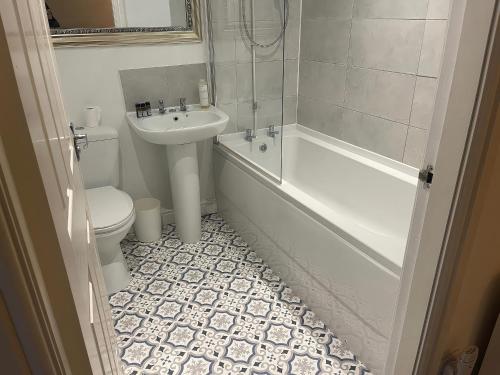 a bathroom with a sink and a tub and a toilet at Bluebell Cottage in Selby