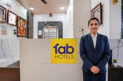 Eine Frau im Anzug steht vor einem Schild von Toalo Hotels. in der Unterkunft Via Sai Lodging I - Nr Nashik Railway Station in Nashik