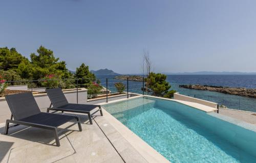 een zwembad met twee stoelen en het water bij Luxurious Home In Dingac With Sauna in Gornji Dingač