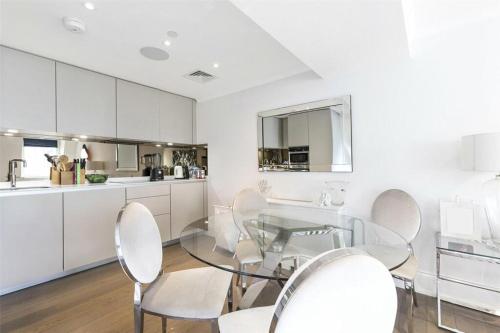 a kitchen and dining room with a glass table and chairs at Prime West End The Covent Garden Design Flat in London