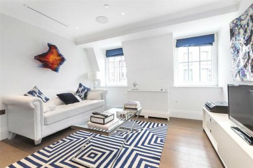 a living room with a white couch and a tv at Prime West End The Covent Garden Design Flat in London