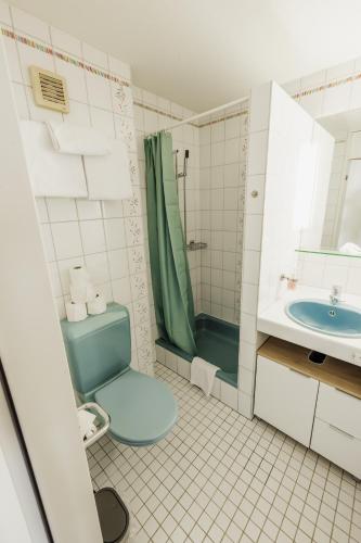 a bathroom with a blue toilet and a sink at Surfers Studio near Interlaken, at lake with pool in Därligen