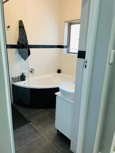 a bathroom with a tub and a toilet and a sink at 41 on RUPERT in Helderberg