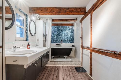 ein Badezimmer mit Waschbecken und Badewanne in der Unterkunft La Maison des Colombages - Proche Strasbourg in Schiltigheim