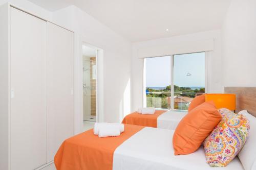 two beds in a white room with a window at Villa Paradise by Escape Home in Son Bou