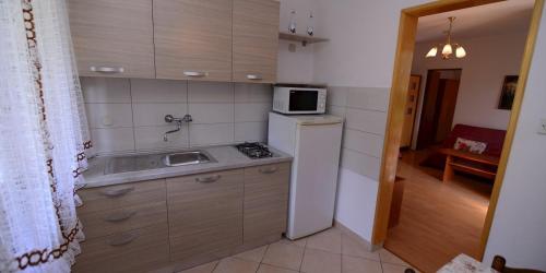 eine kleine Küche mit Spüle und Kühlschrank in der Unterkunft Arsenio in Veli Lošinj