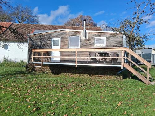 a house with a large deck on a yard at Tinyhaus Lara in Bad Waldsee