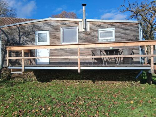 a house with a large deck with two chairs at Tinyhaus Lara in Bad Waldsee