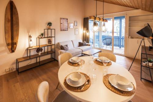 uma sala de estar com uma mesa e cadeiras brancas em Surfers Lodge near Interlaken, at lake with pool em Därligen