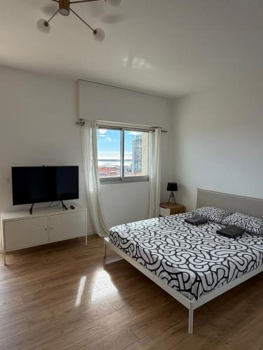 a bedroom with a bed and a flat screen tv at New Panoramic studio overlooking Monaco in Beausoleil