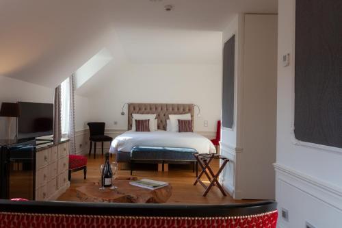 ein Hotelzimmer mit einem Bett und einem Fernseher in der Unterkunft le clos des belvals in Vertus