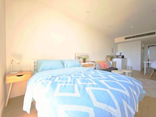 Box Hill Bright and Cozy Hotel Style One Bedroom Suite Kitchenette Ideal for Short Stays في بوكسهل: غرفة نوم بسرير ازرق وغرفة معيشة