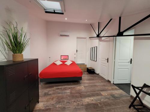 a bedroom with a red bed and white walls at L'Appart Indus et Parking Privé in Blois