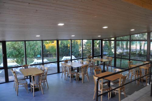 a dining room with tables and chairs and windows at Penzion TCV Pardubice in Pardubice