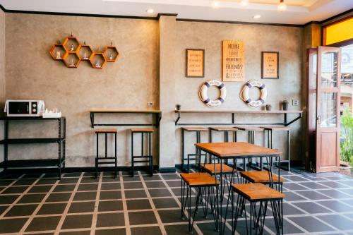 a restaurant with tables and stools in a room at Lanta Chaolay in Ko Lanta