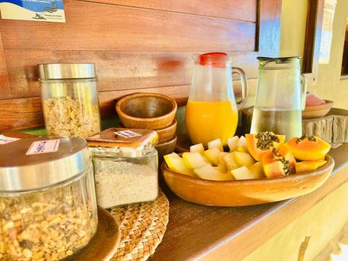 Amigos do Vento Chalés e Kite Point في توروس: كونتر مع وعاء من الفاكهة وجار من الطعام