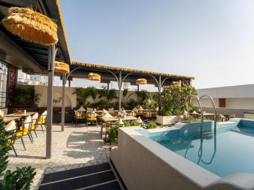 an outdoor patio with a pool and tables and chairs at Moustache Jaipur,Hostel & Rooftop Bar in Jaipur