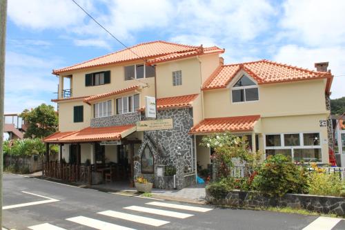 a house with an orange roof on a street at IlhaMontanha - Serras da Ilha in Santana