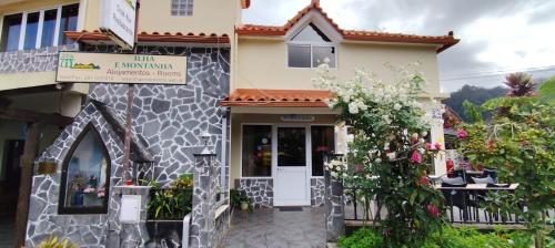 a building with a white door and some flowers at IlhaMontanha - Serras da Ilha in Santana