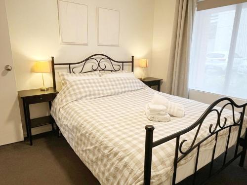 a bedroom with a bed with two lamps and a window at Cosy Ground Floor Walk to Adelaide Oval, City, Zoo & More in Adelaide