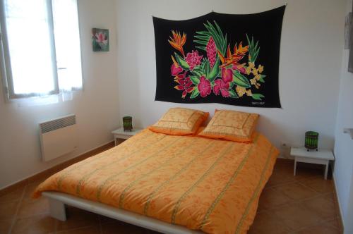 a bedroom with a bed with an orange comforter at Villa Aghjanella in Patrimonio