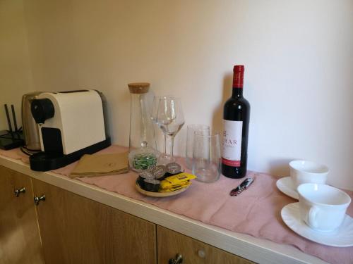 una botella de vino y copas en un mostrador en Simonette Maisonette - Mountain Retreat, en Buşteni