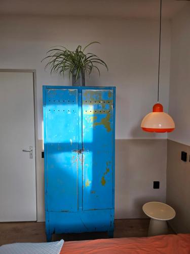 a blue cabinet with a potted plant on top of it at Herberg Hanenberg in Wissenkerke