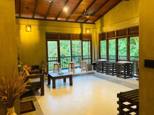 ein Wohnzimmer mit Fenstern und einem Balkon in der Unterkunft Summer Waves Villa in Ahangama