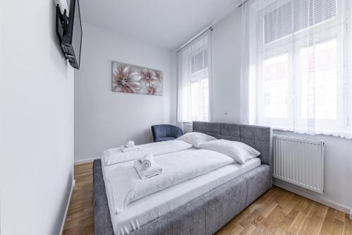 Un pat sau paturi într-o cameră la Compact Luxury by JR City Apartments