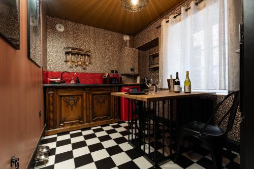 loveroom le donjon في آنس: مطبخ به طاولة وأرضية مربعة الشكل