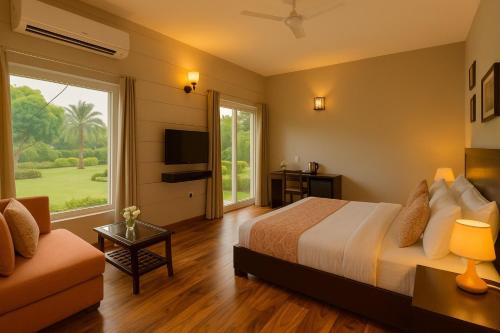 a bedroom with a bed and a television and a couch at Pearl Grand Boutique Cottage In Omaxe Anandam Vrindavan -# Premium AC Rooms With Balcony # Big Parking # Lift # Garden # Peaceful Area # Near Prem Mandir # Property Of The Year # Most Awarded in Vrindāvan