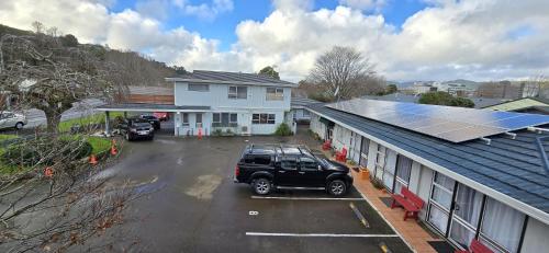 a car parked in a parking lot next to a building with solar panels at Motel 22 in Lower Hutt