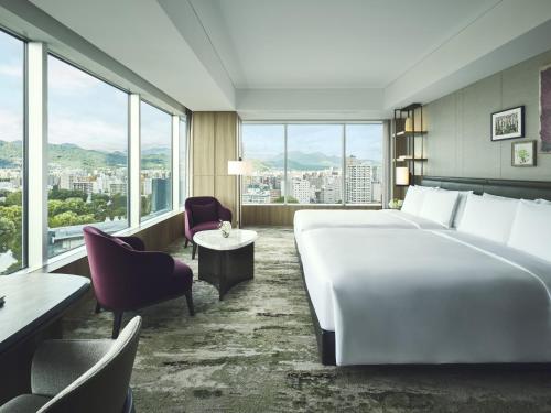 a hotel room with a large bed and windows at InterContinental Sapporo by IHG in Sapporo