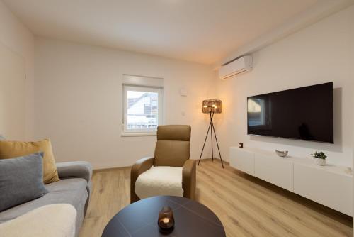 a living room with a couch and a tv at Apartments Lia in Ljubljana