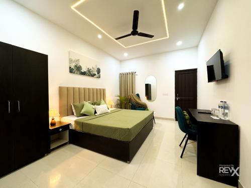 a bedroom with a bed and a desk and a television at Wanna Ayodhya in Ayodhya