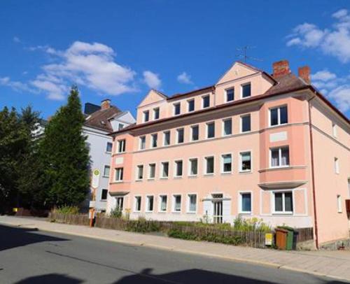 霍夫Monteur Budget-Ferienhaus in Hof, stadtnähe的街道边的一座粉红色大建筑
