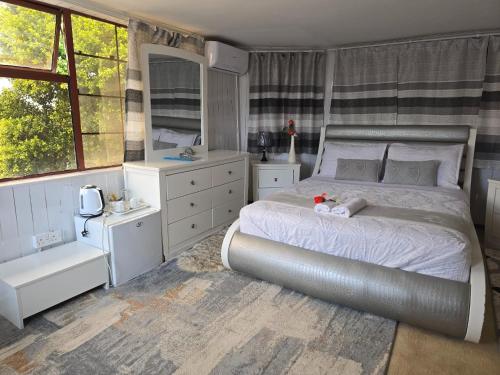 Apelles Palace Guest House - executive room 2 في Tlokweng: غرفة نوم بسرير كبير ونافذة كبيرة