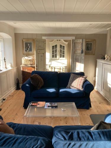 Una sala de estar con un sofá azul y una mesa. en 18th century gem with soul, en Ærøskøbing