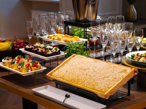 クラクフにあるHotel Palladianのテーブル(食べ物、ワイングラス付)