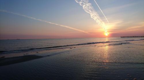 una puesta de sol en una playa con el océano en Haus Meeresstern, en Wangerooge